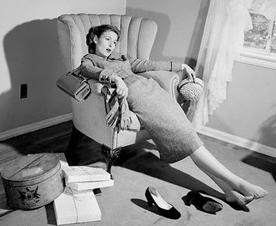 A Black and white image of a girl sitting on a couch with a lazy gesture